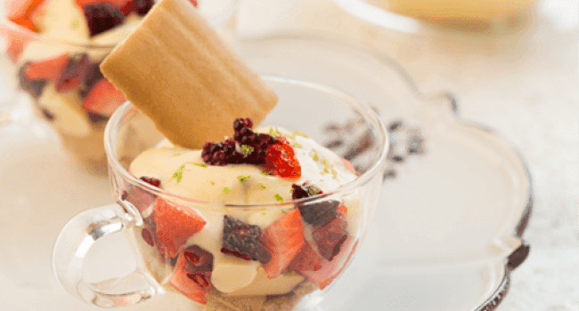 Postre de crema y frutas rojas